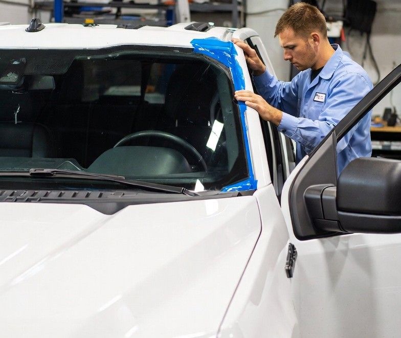 installing a new windshield onto a modern white Ford F-150